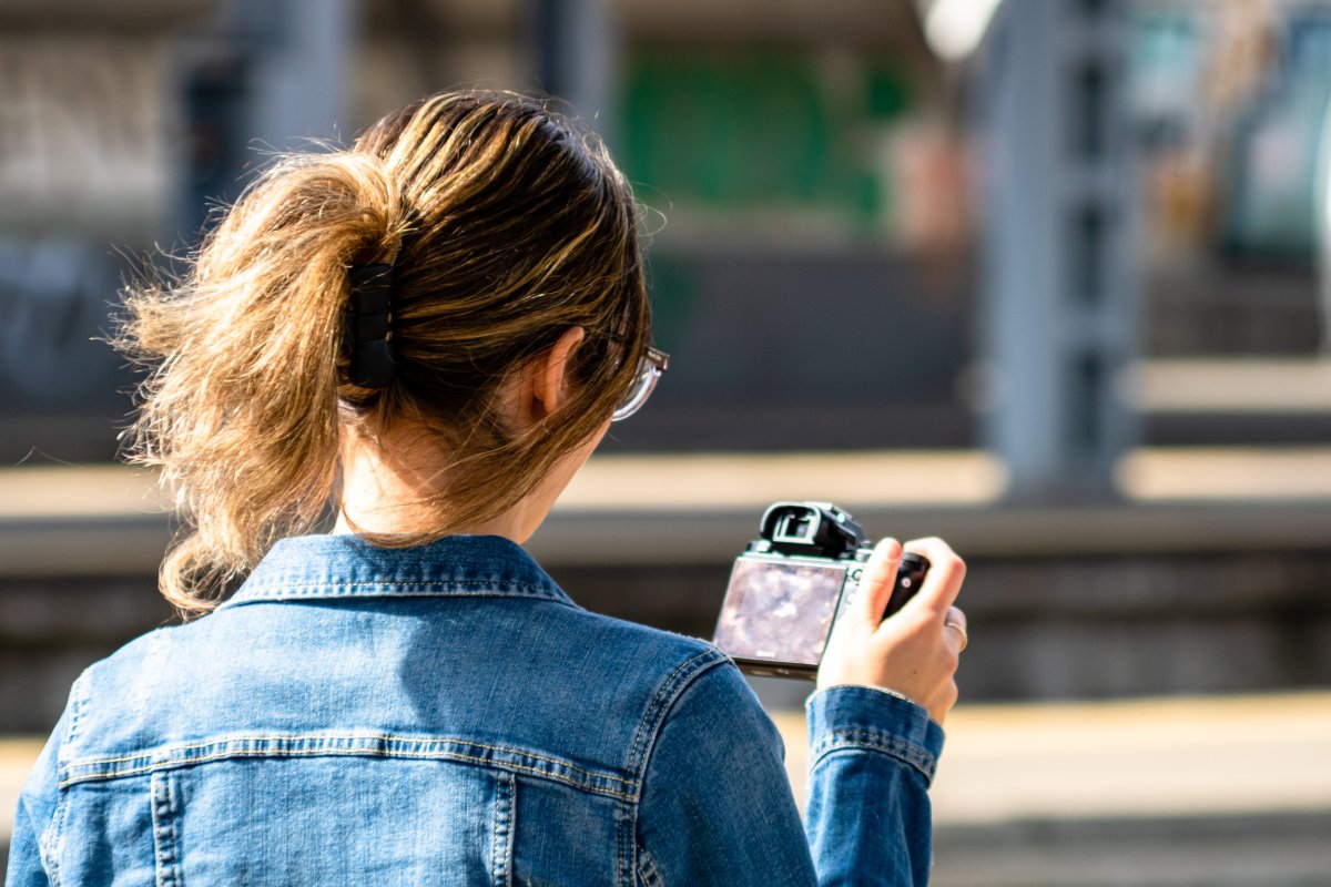 Una mujer revisando la foto en la cámara digital