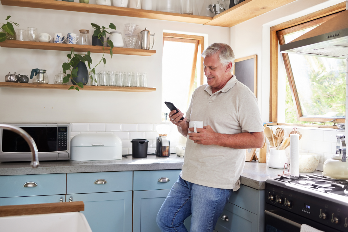 Man Blue Jeans Smiles Kitchen Mobile Phone