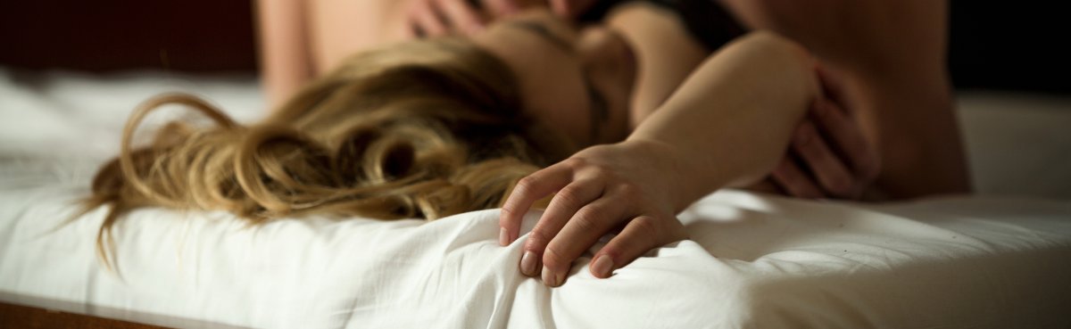 A couple is intimate in bed together