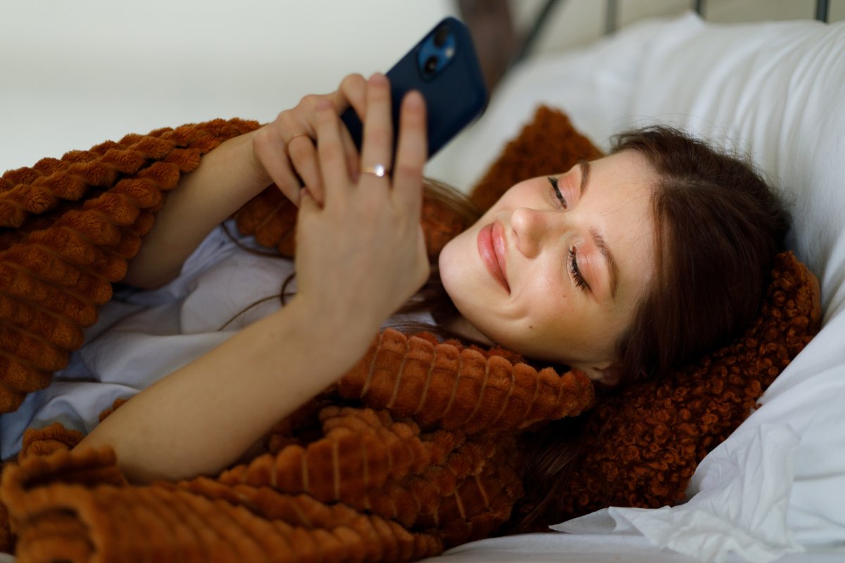 A woman smiles on her phone