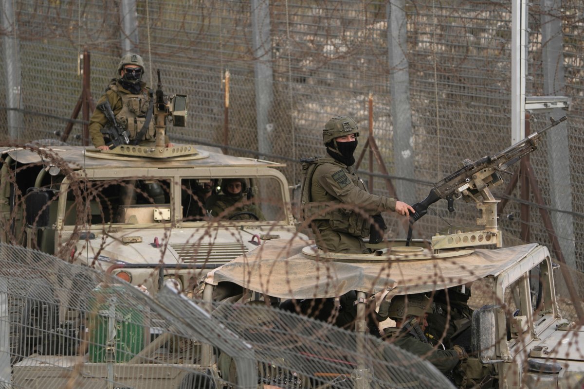 Israeli soldiers stand on armoured vehicles