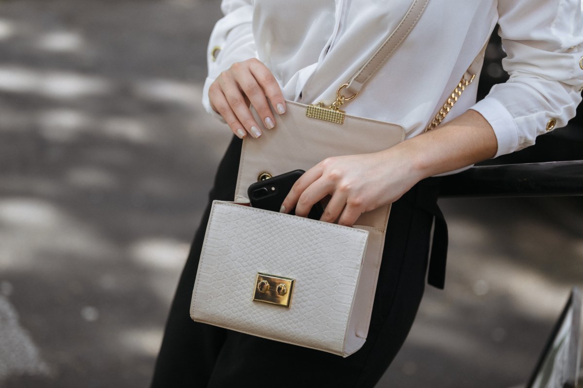 Woman Opens Cream Handbag Outdoors