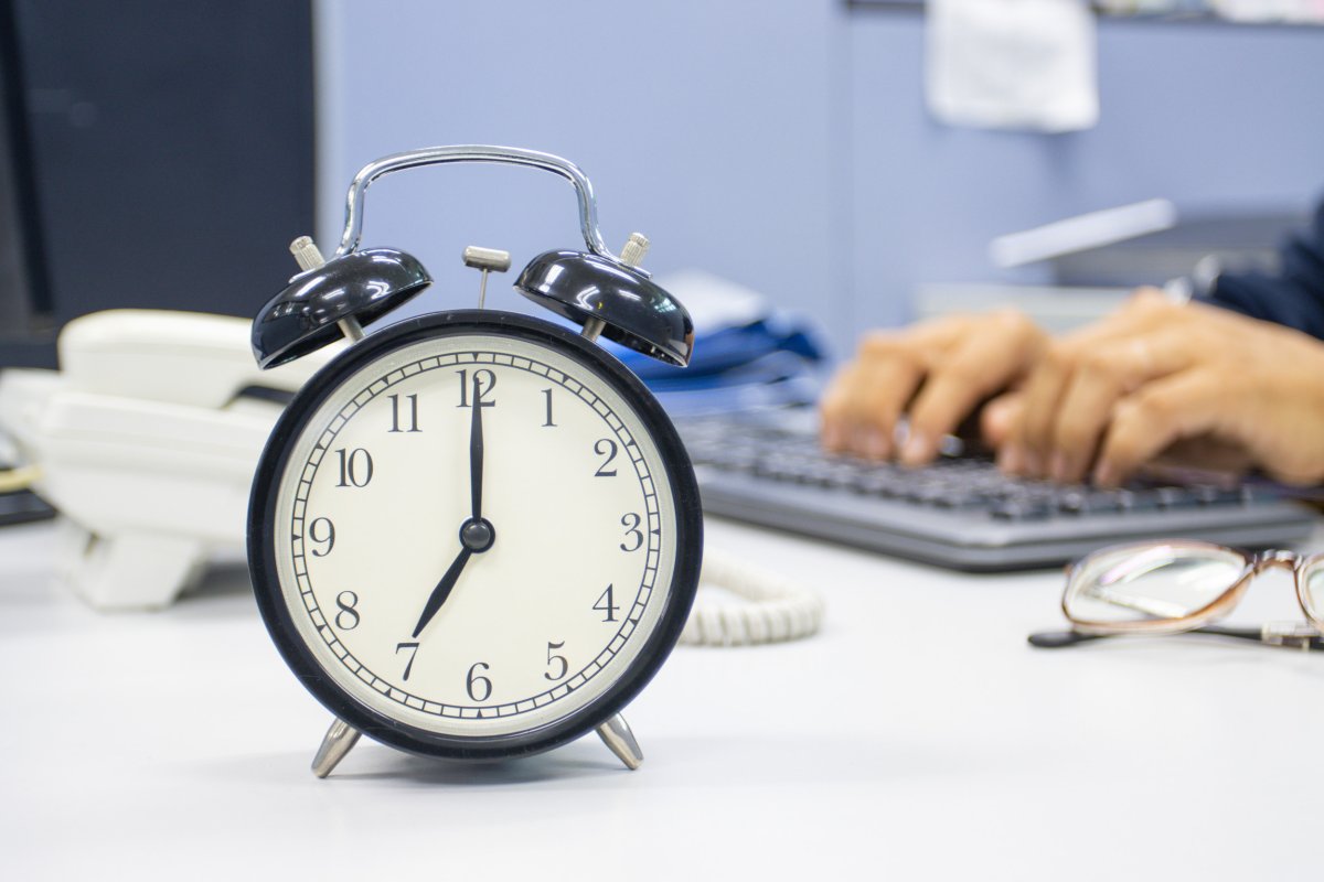 Person at work, clock saying 8 a.m.