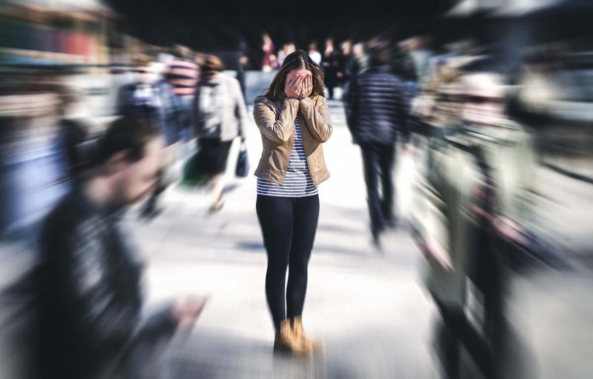 Stock image of a woman surrounded by blurred figures representing schizophrenia