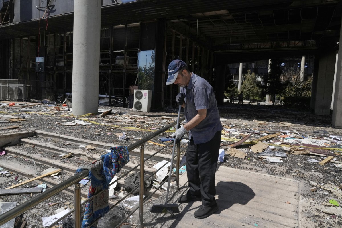 Trabajador iraní barre escombros