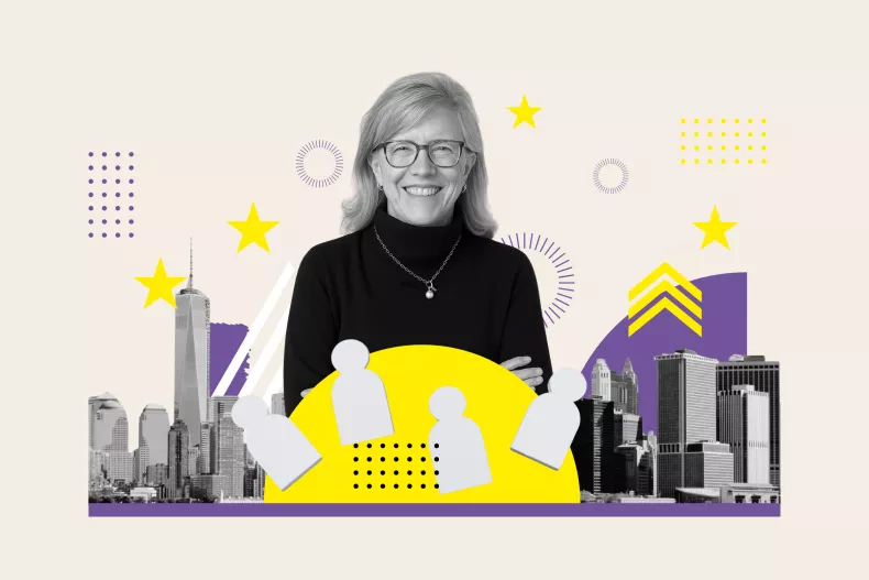 A black-and-white photo of Beth Stewart smiling at the camera. In the backdrop is the New York City skyline.