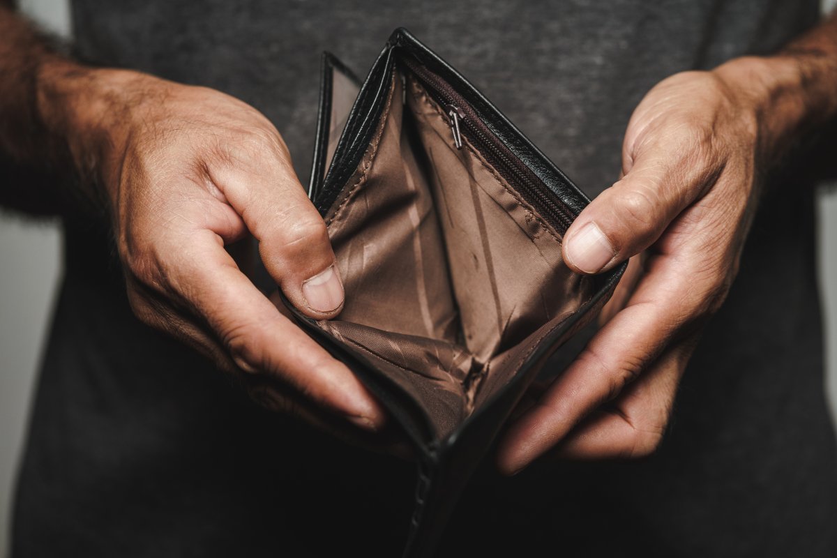 A man holds open an empty wallet