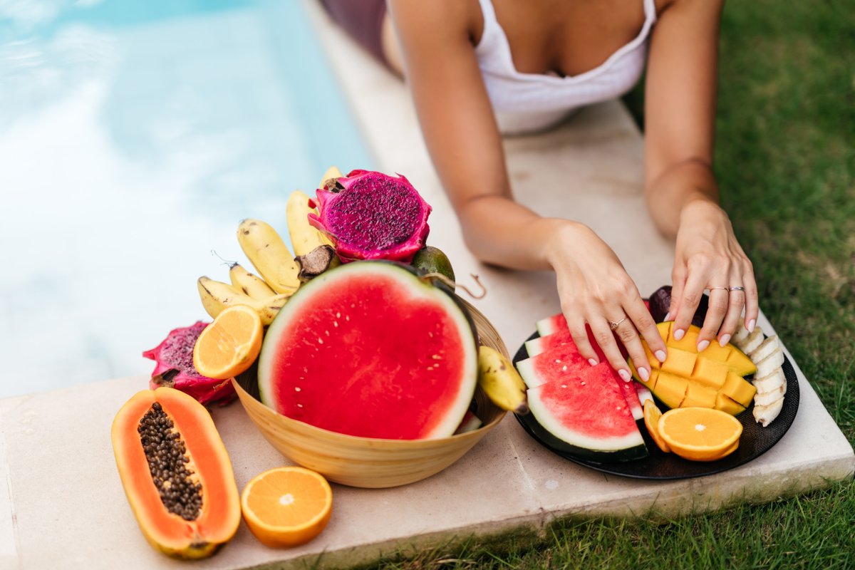 Woman in Bali near bowl of fruits.