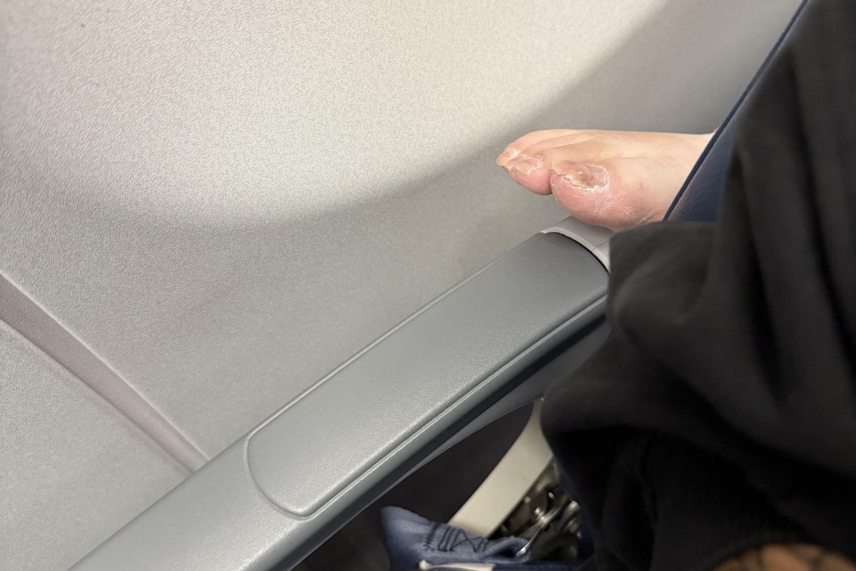Bare foot on a plane seat armrest.