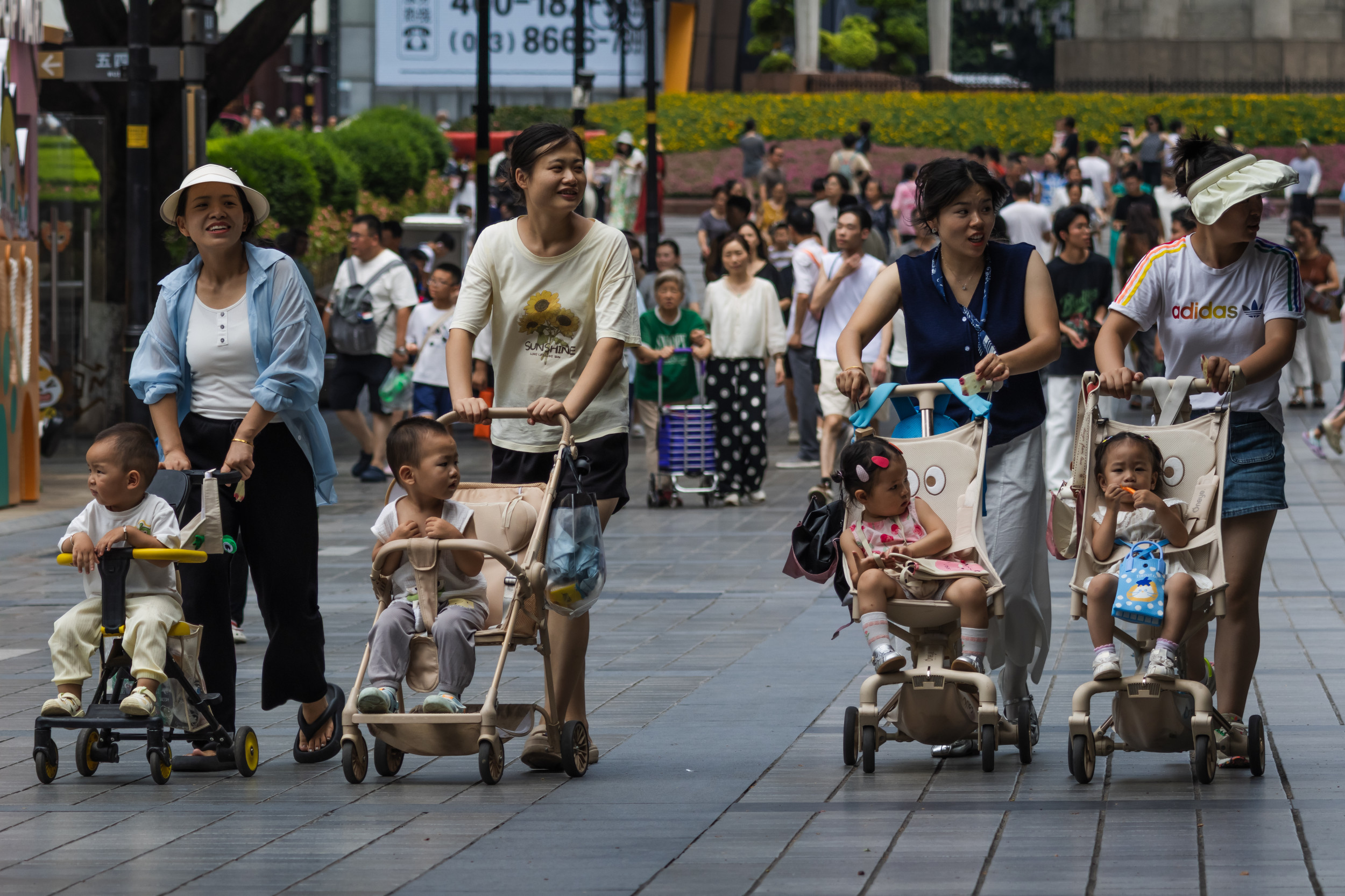 https://d.newsweek.com/en/full/2698036/women-push-toddlers-strollers-chongqing.jpg