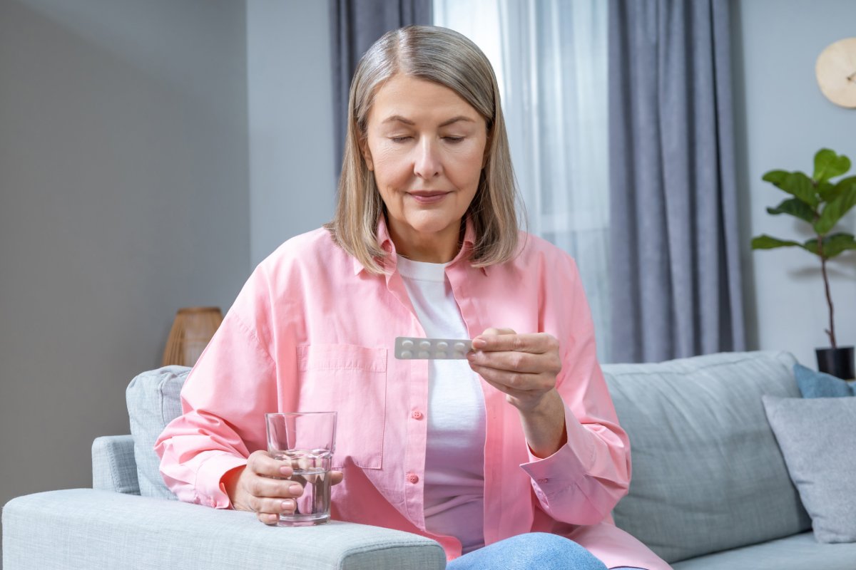 Mid aged woman taking HRT pills