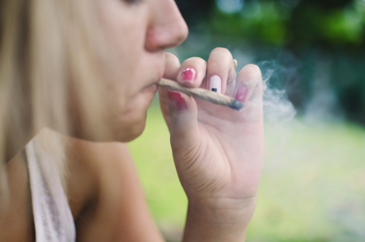 Uma maconha feminina fuma uma articulação