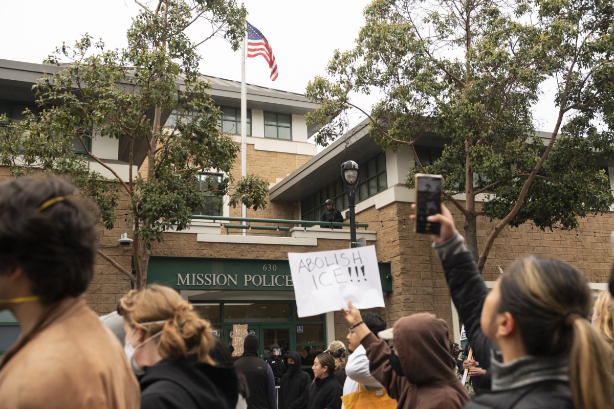Protesters hold a sign reading "Abolish ICE"