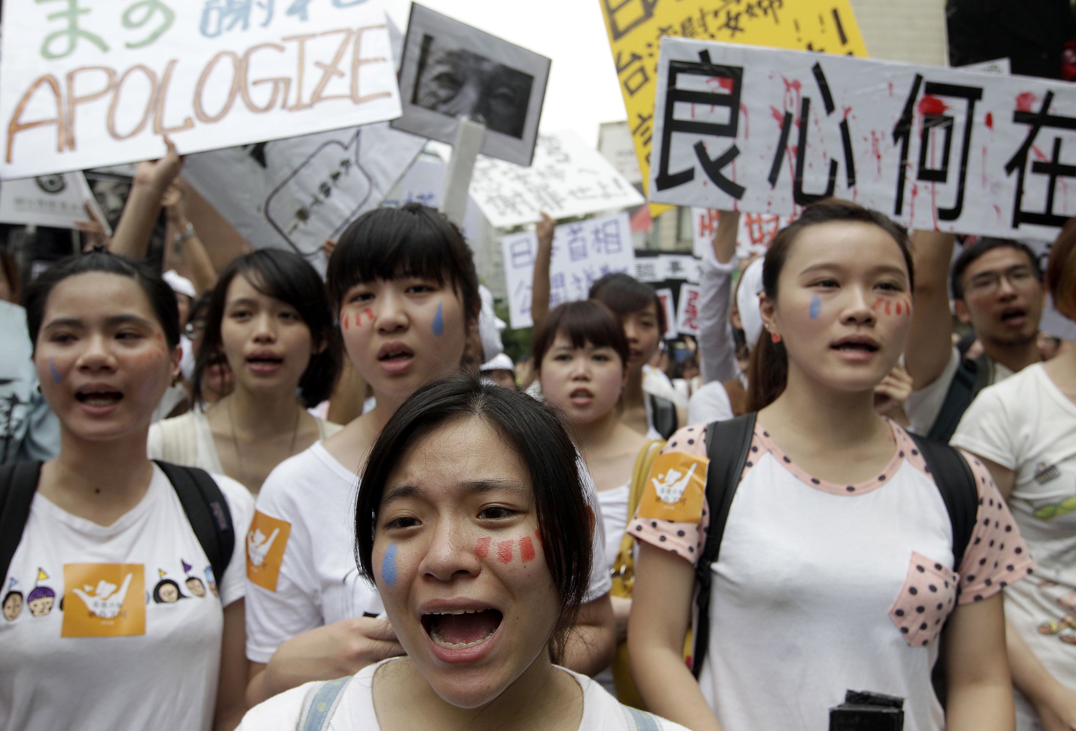 Activists take part in a protest in Tapei over Japanese troops' use of "...