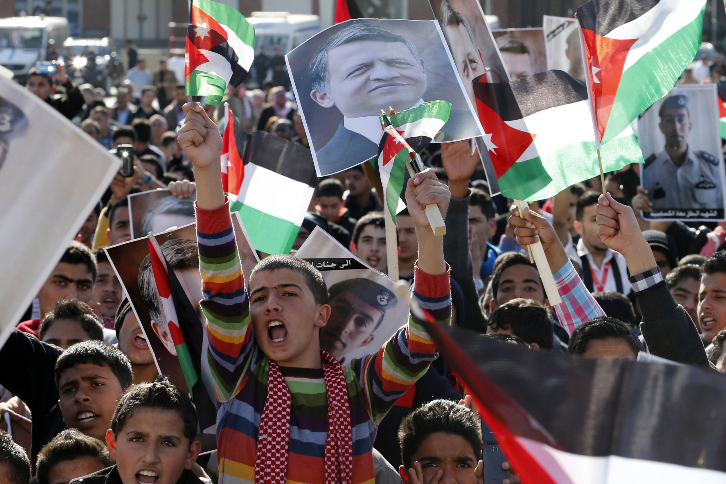 Protesters hold up pictures of Jordan's King Abdullah and pilot Muath al-Kasaesbeh