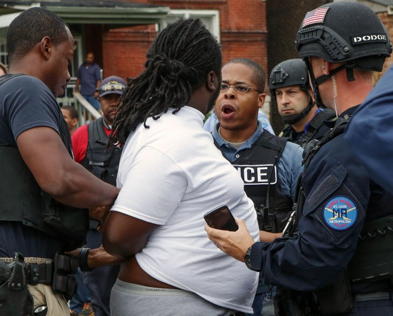 A police officer and a protester have a confrontation during an arrest. 