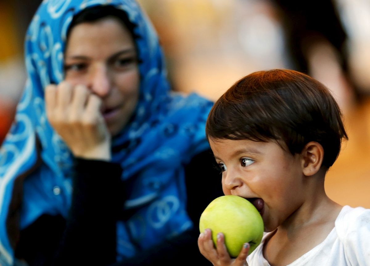 Child Refugee Eats An Apple Child Refugee Eats An Apple