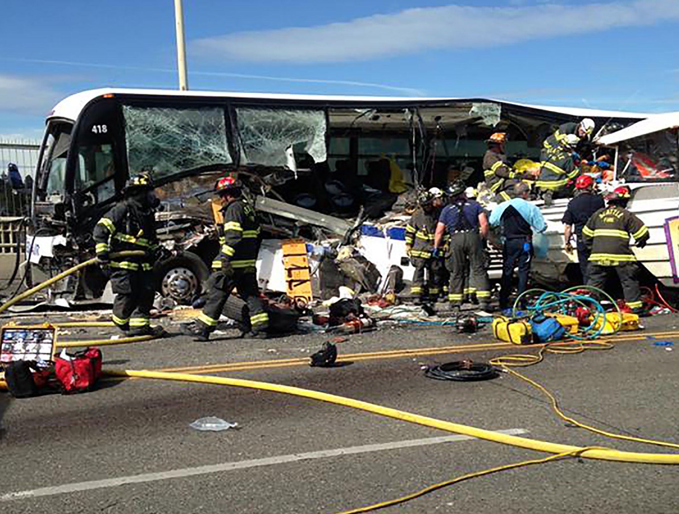 Firefighters assist victims after a crash between a bus and a tour vehicle ...