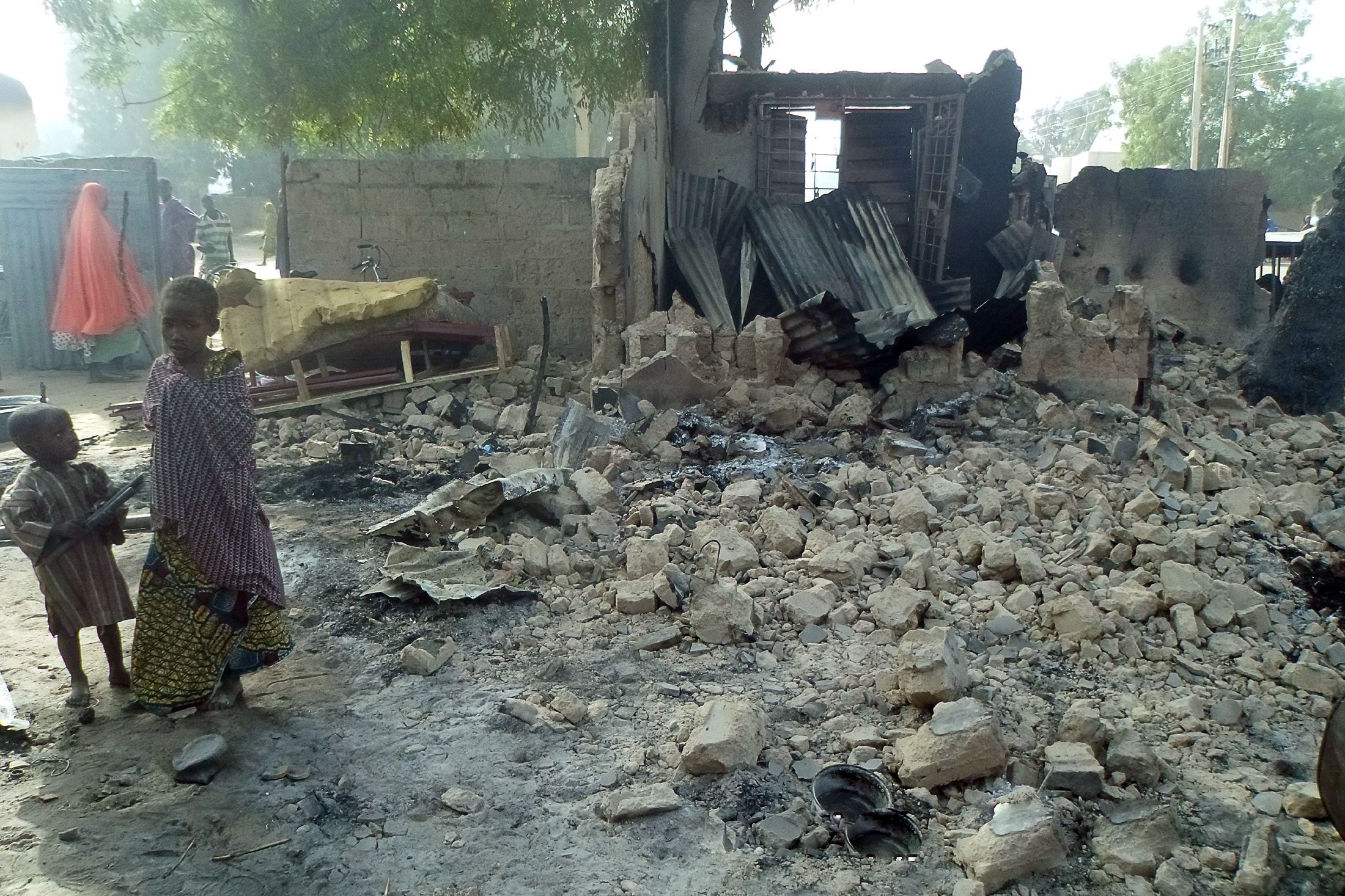 Children stand near rubble after Boko Haram attacks in Dalori, Nigeria.