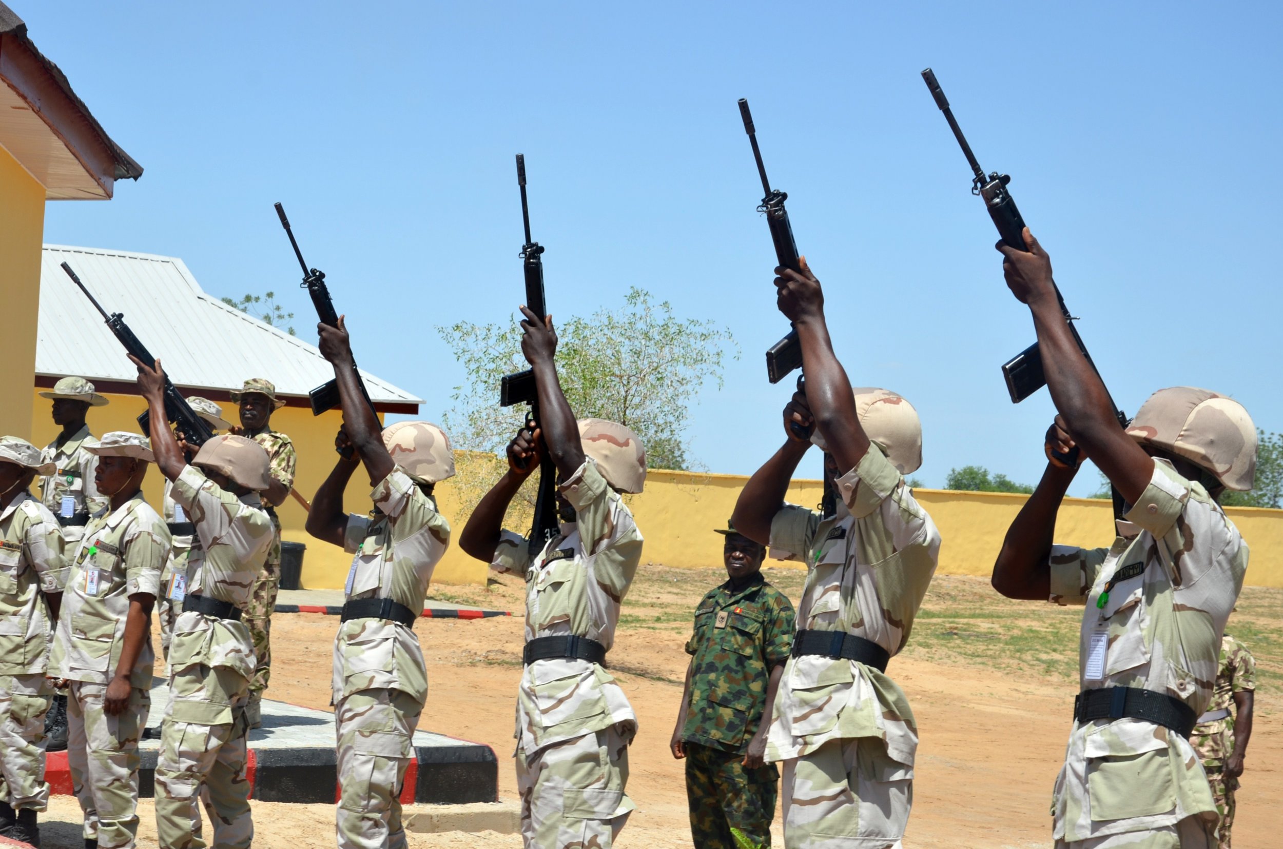 Nigerian soldiers shoot into the air to mark release of detainees cleared of being Boko Haram members.