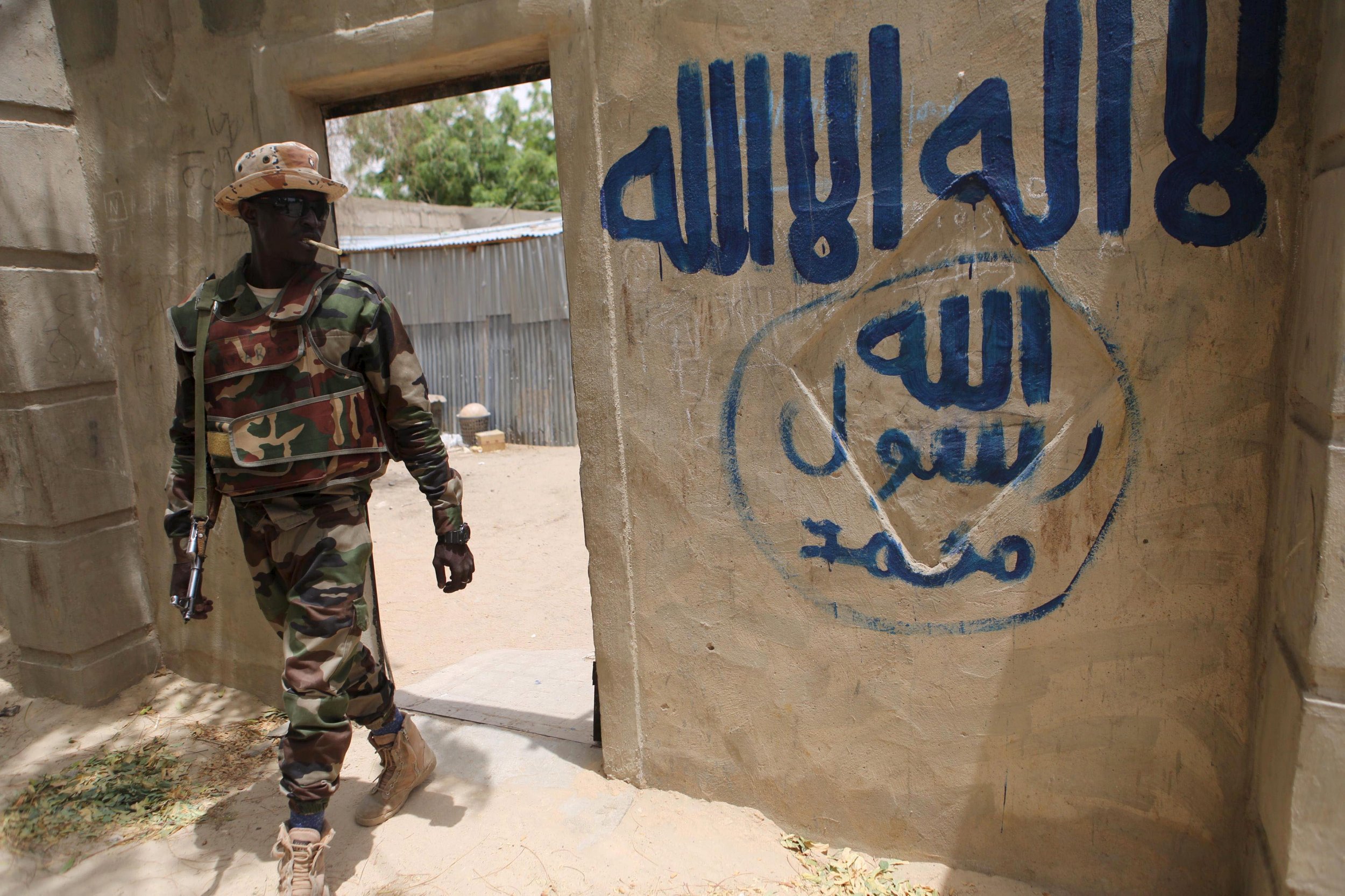 Nigerien soldier walks out of a house reportedly seized by Boko Haram in Damasak.