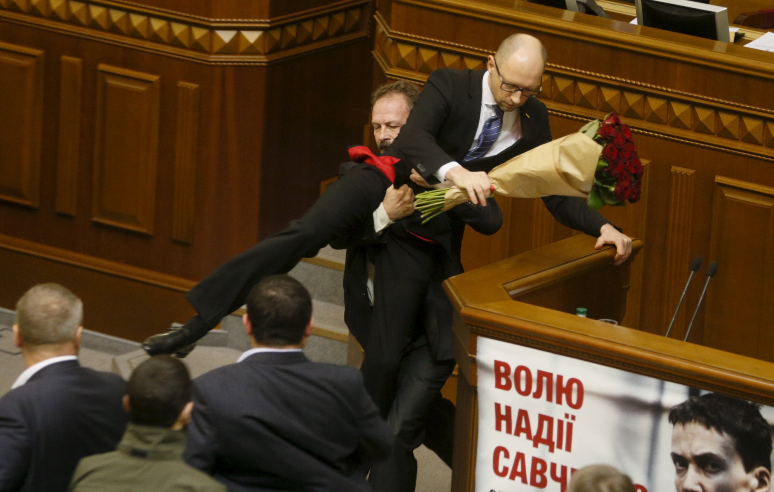 Ukraine PM Yatseniuk is pulled from the podium in parliament by MP