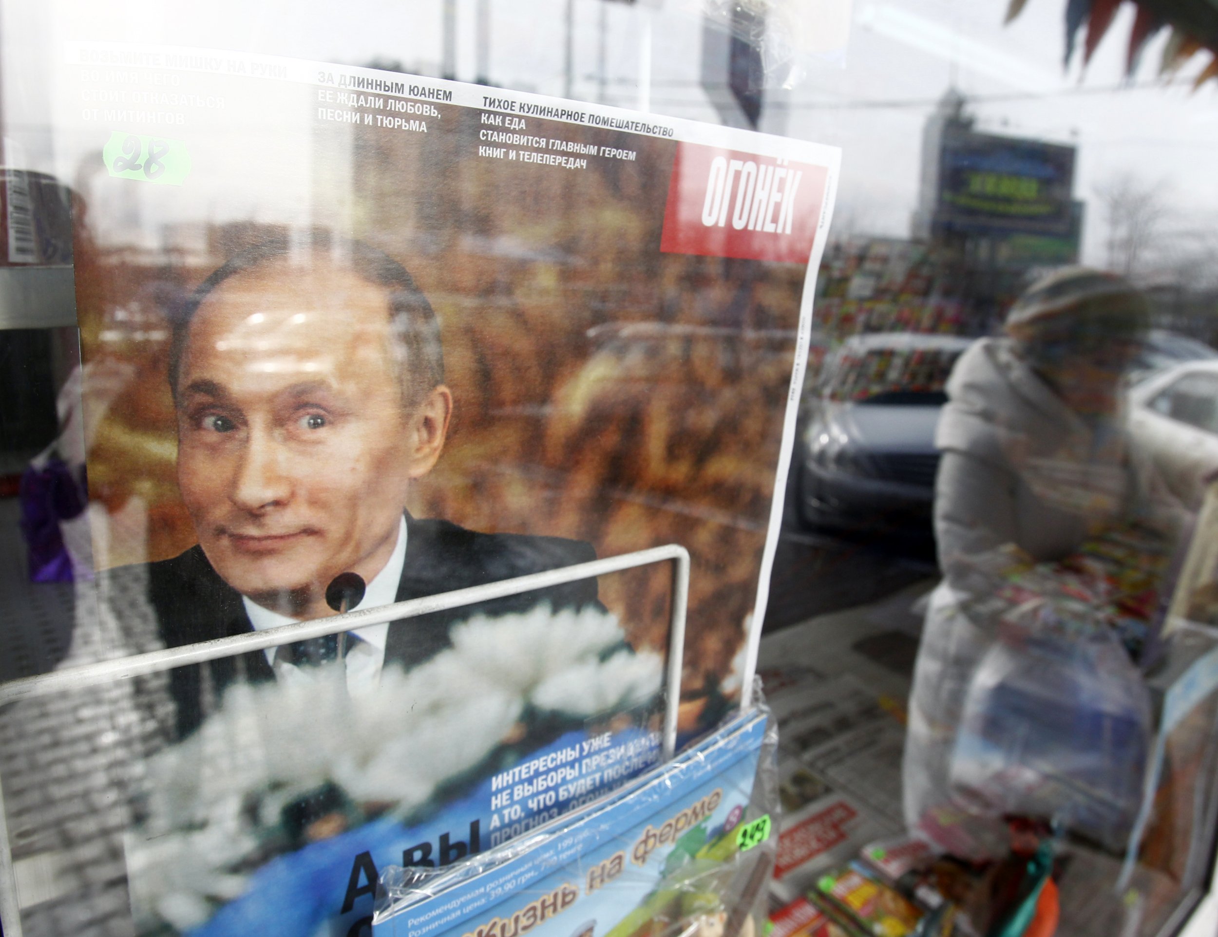 Putin smiles on the cover of a magazine at a kiosk