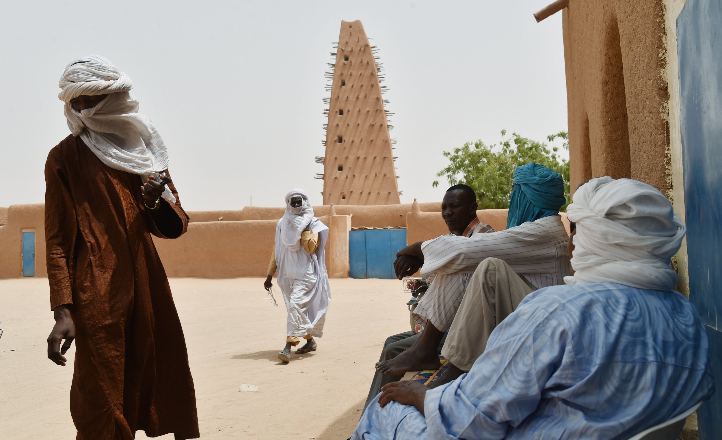 Nigeriens stand near a mosque in Agadez.