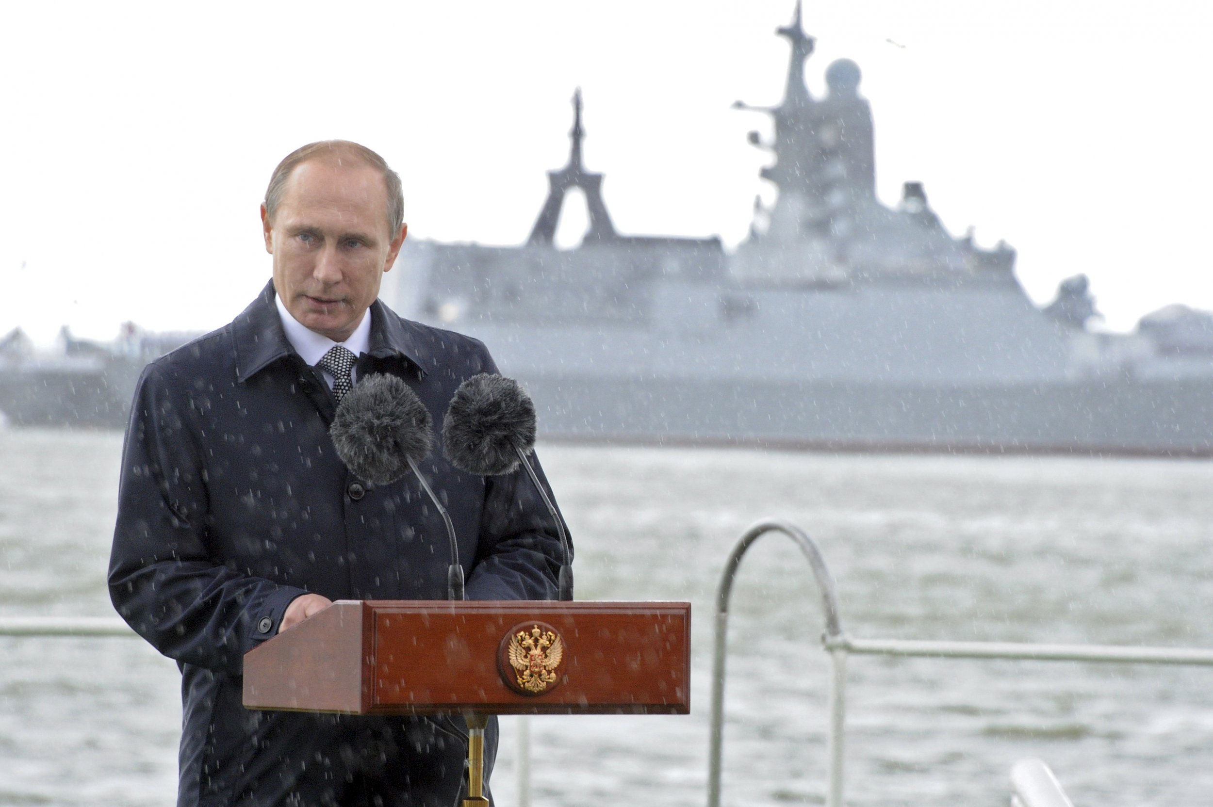 Putin speaks in front of a Russian warship