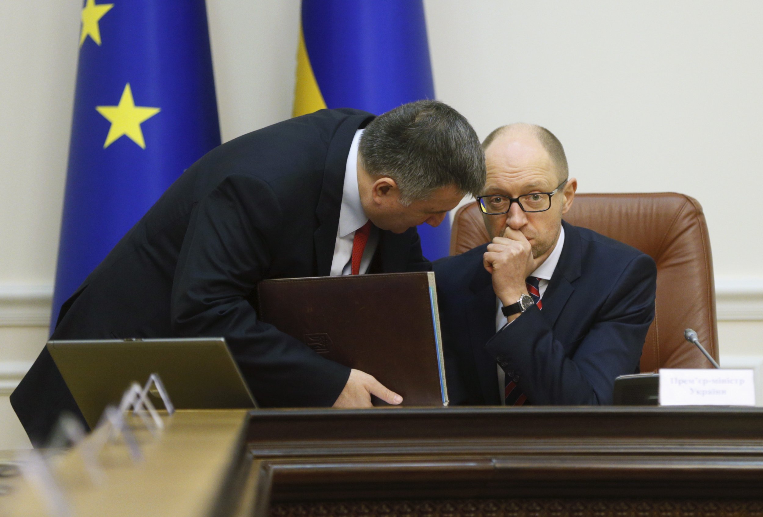 Avakov leans in to speak with Yatsenyuk at his desk