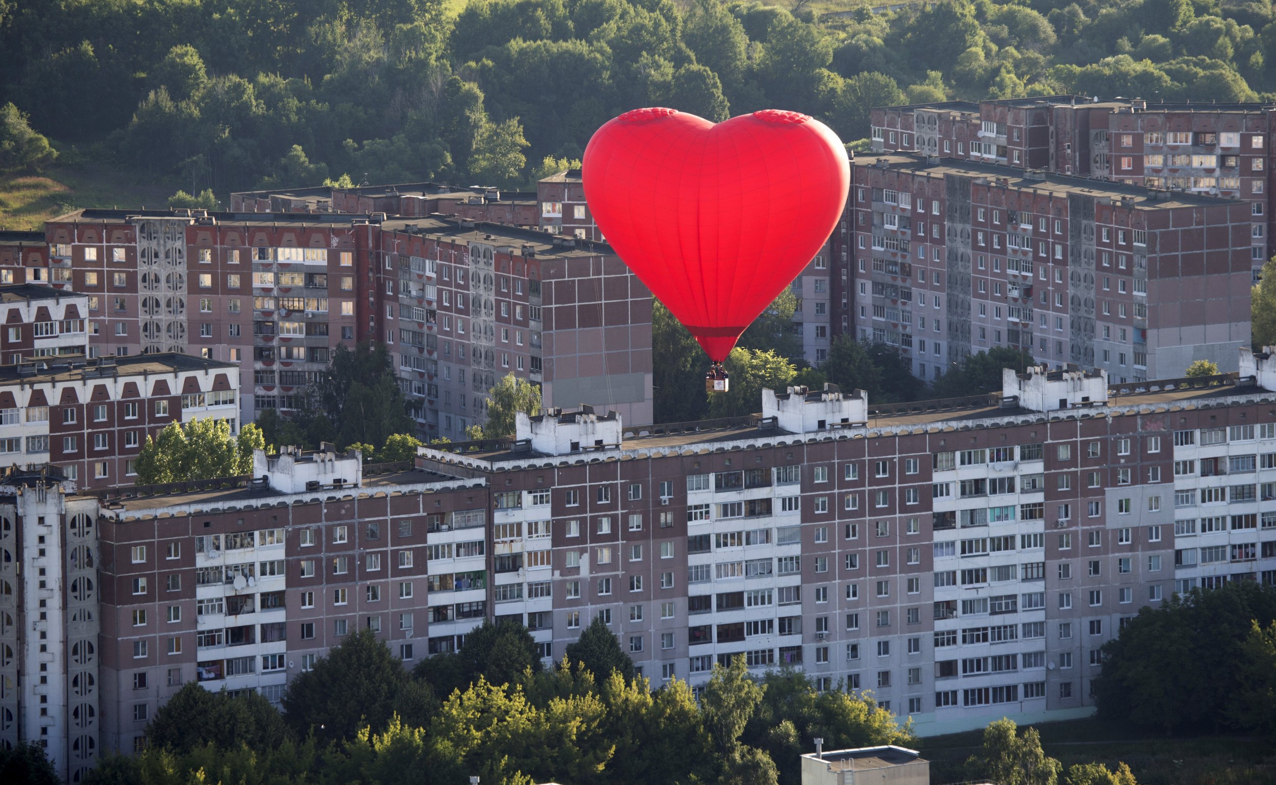 Heartshaped hot air balloon flies above communist buildings