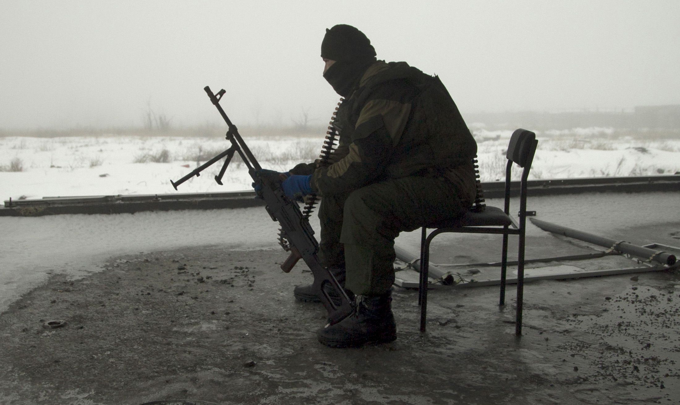 Ukraine rebel sits with his gun in Donetsk