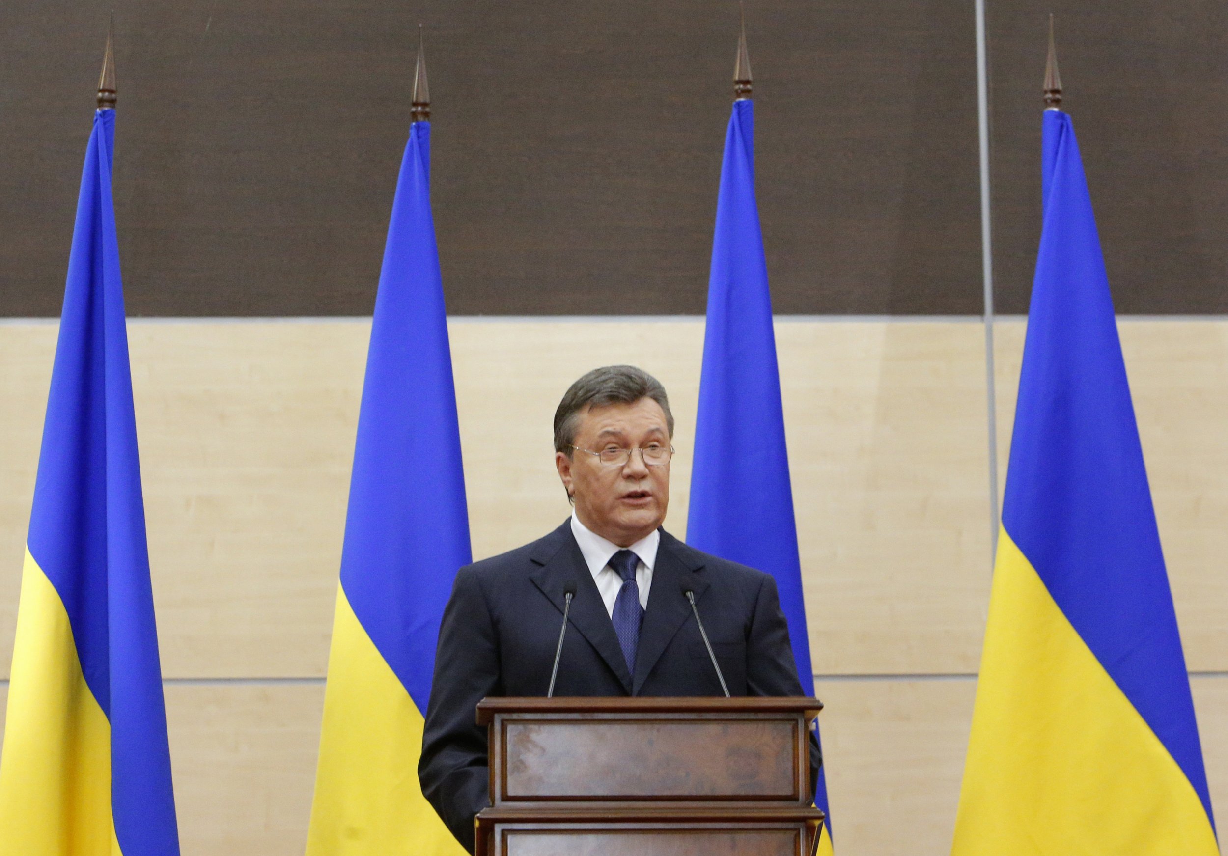 Yanukovych speaks in front of Ukrainian flags