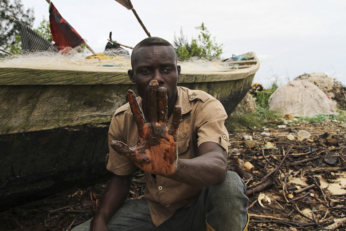 A Niger Delta fisherman shows an oil slick.