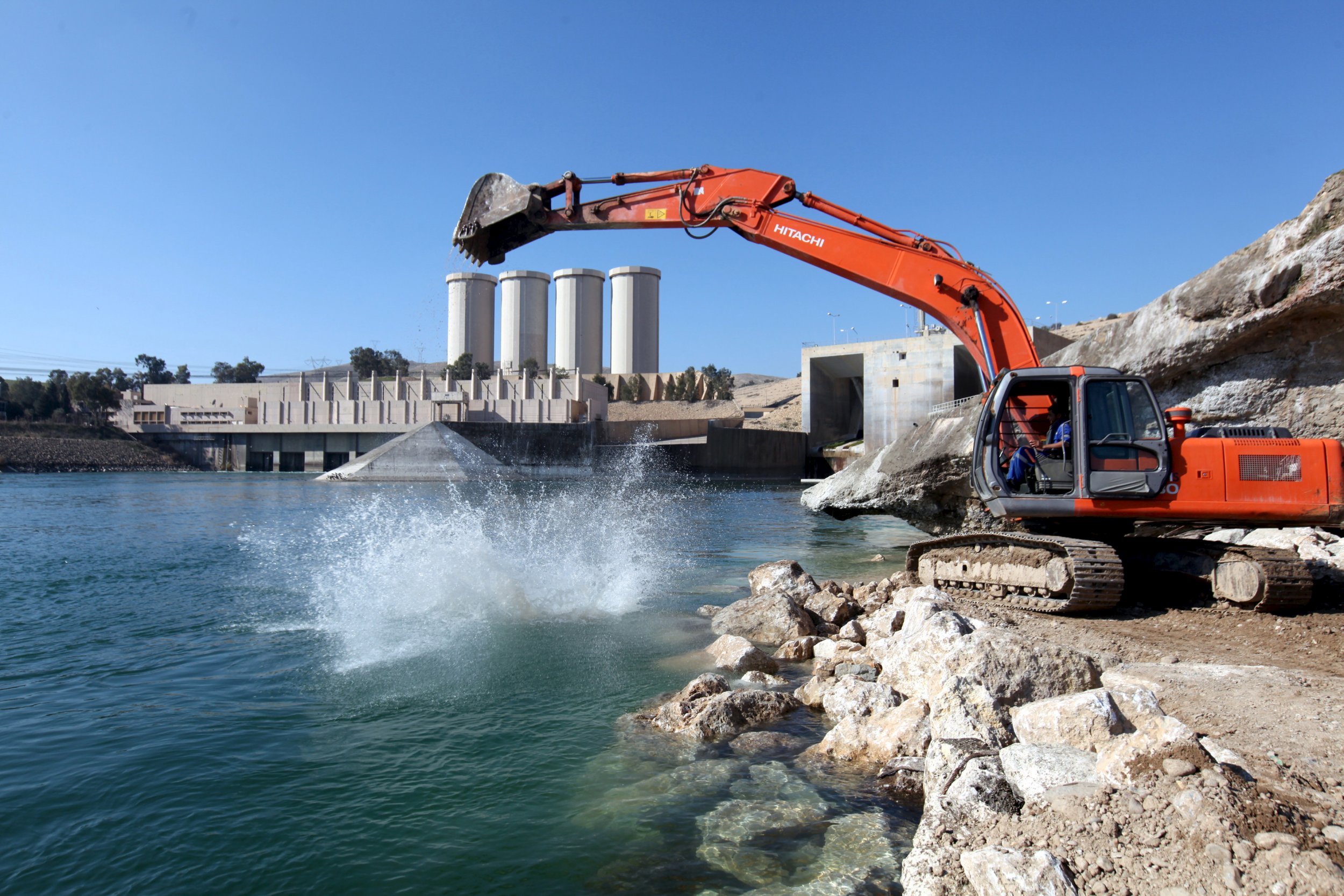 Building crew digs into the Tigris river above the dam