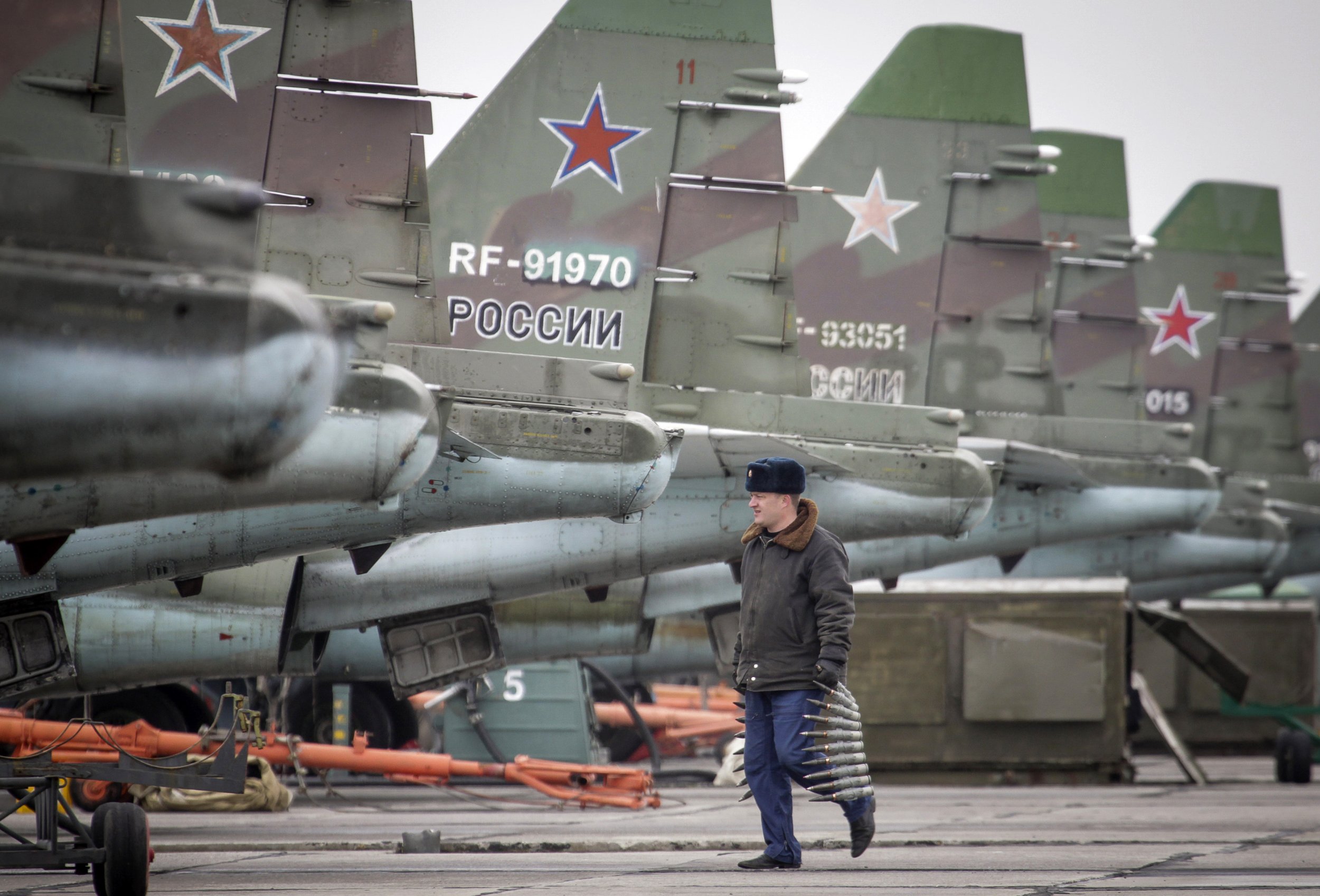 Russian soldier walks past tails of Su25 jets