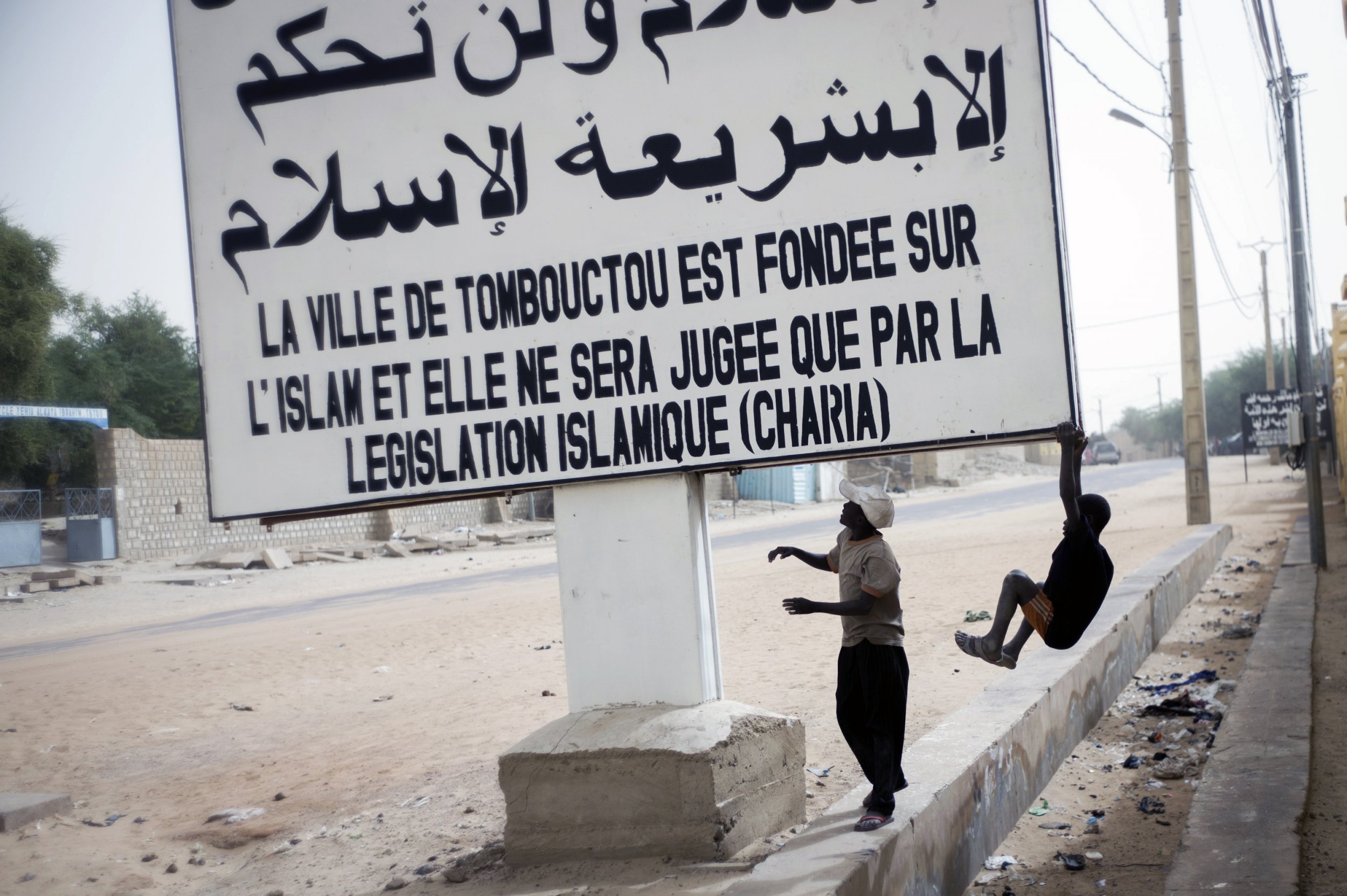 Children play on a sign in Timbuktu, northern Mali.