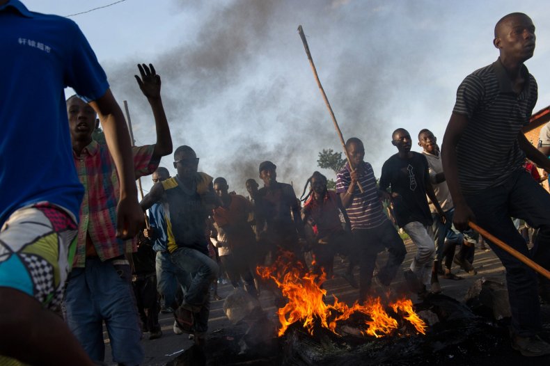 Protesters in Burundi run towards police lines.