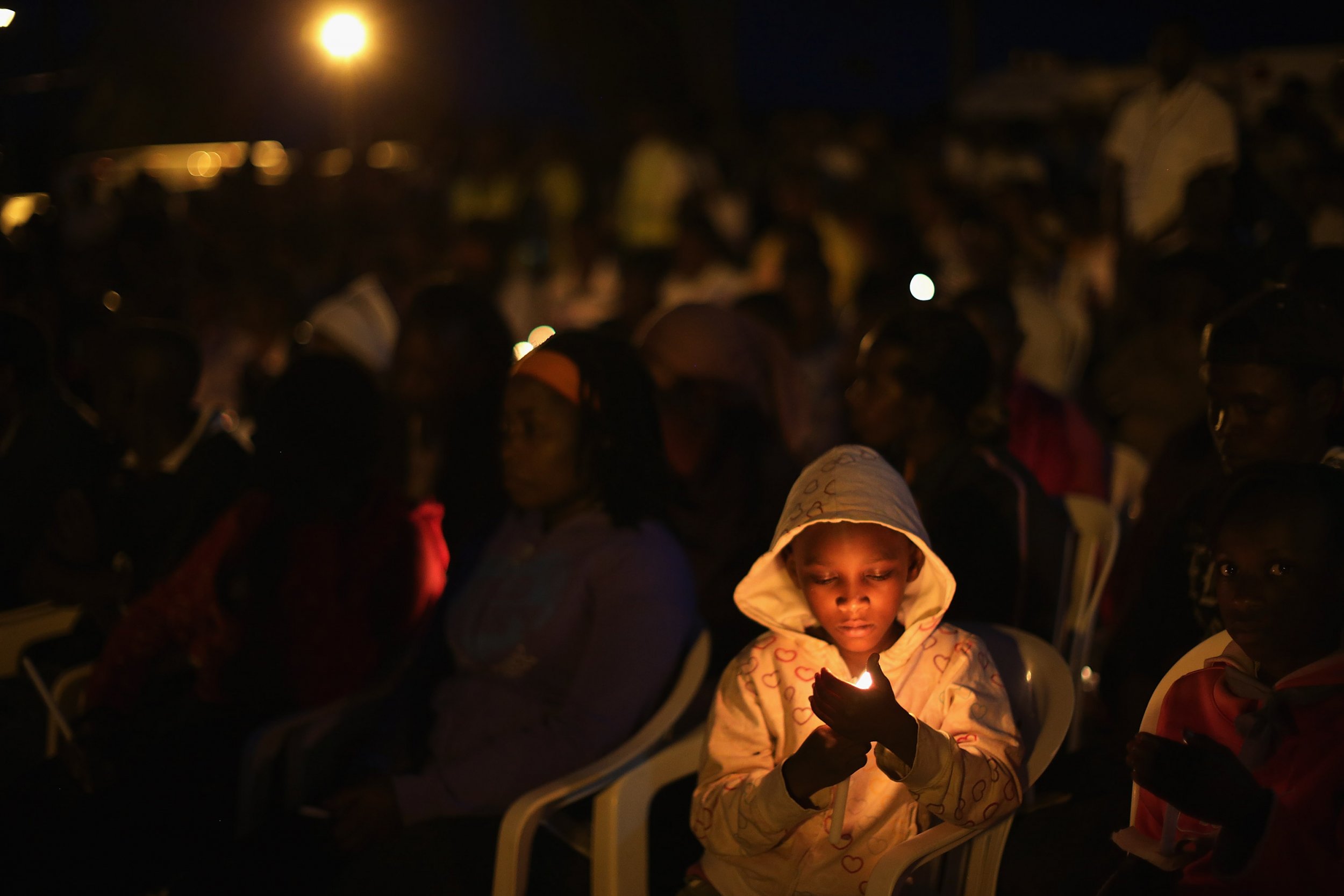 A child holds a candle at a Rwandan genocide memorial.