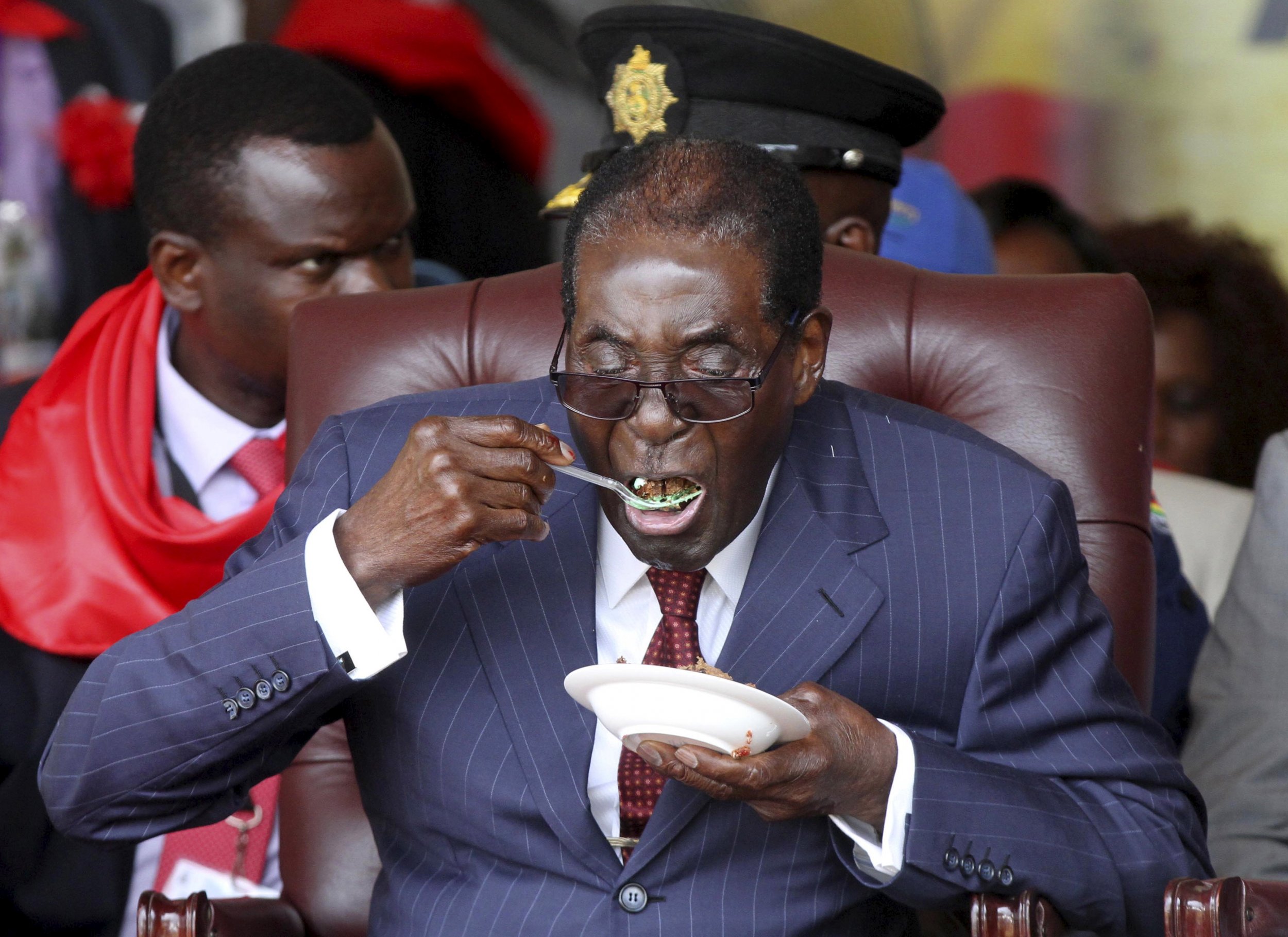 Zimbabwe President Robert Mugabe eats cake at his 92nd birthday celebrations.