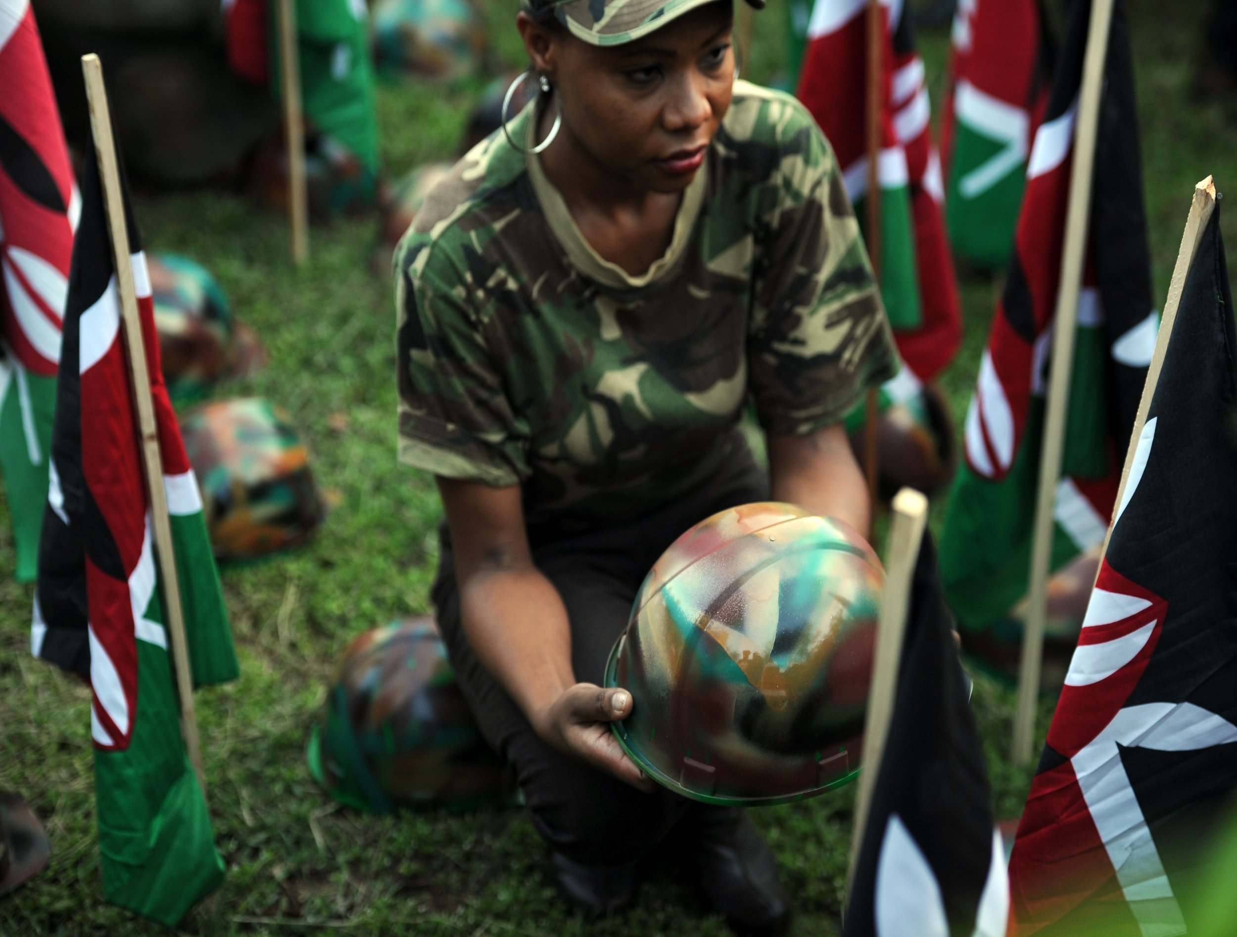 A woman holds a helmet at a vigil for Kenyan soldiers killed by Al-Shabab.