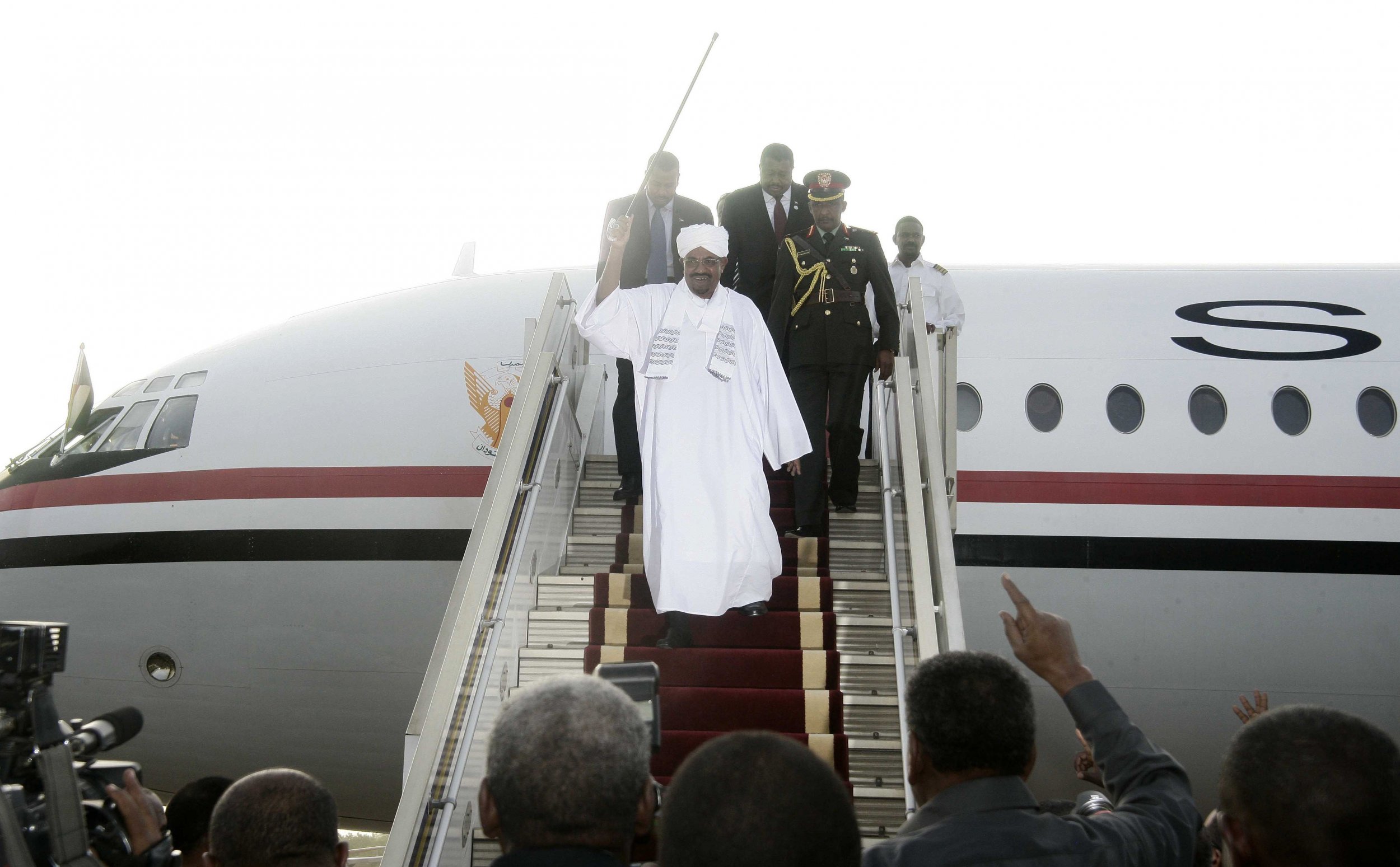 Sudanese President Omar al-Bashir waves upon returning to Khartoum from Johannesburg.