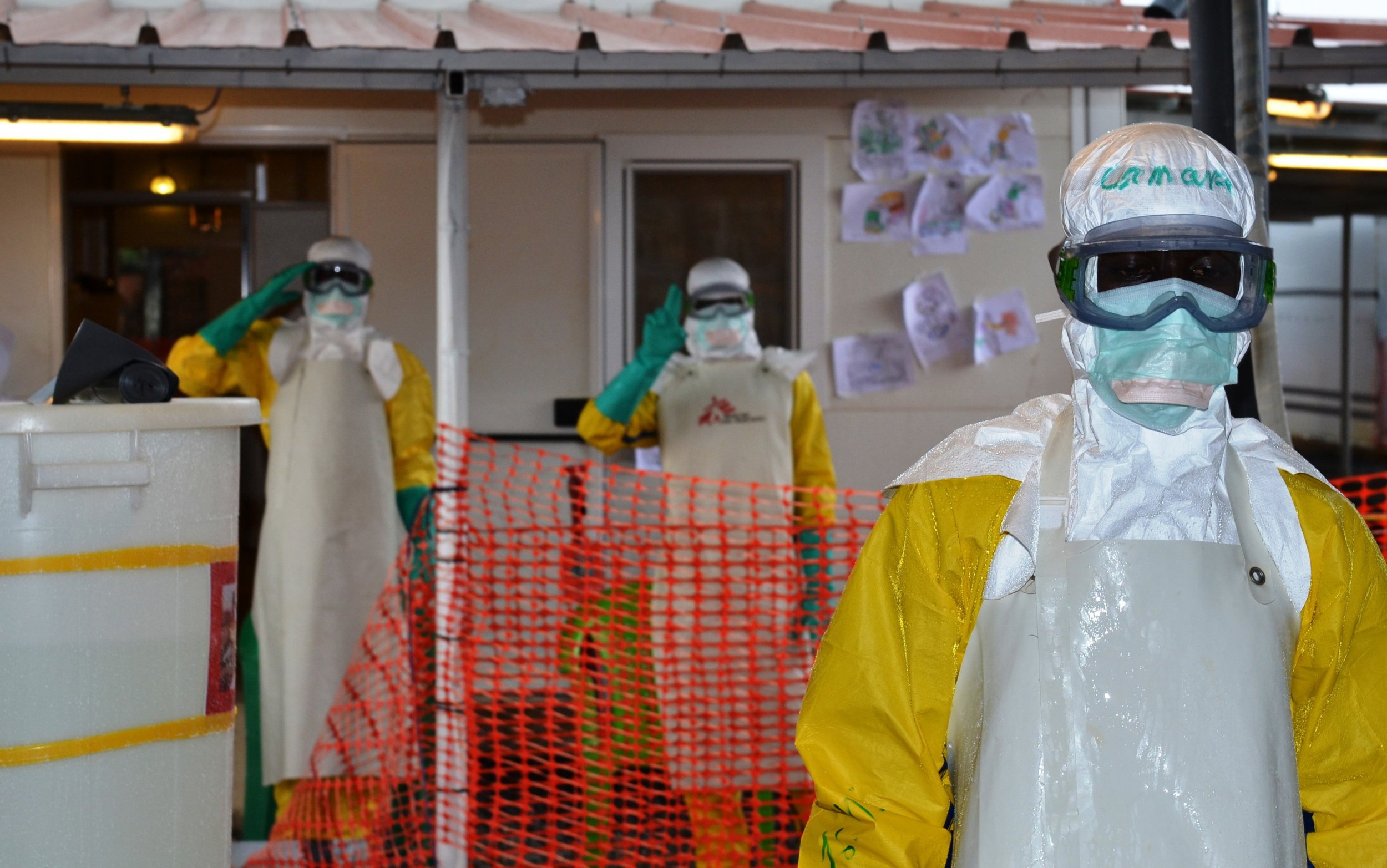 Ebola health workers gesture in Guinea.