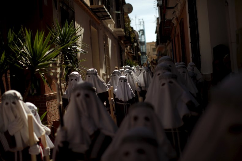 Penitents take part in Easter procession in Malaga Spain.