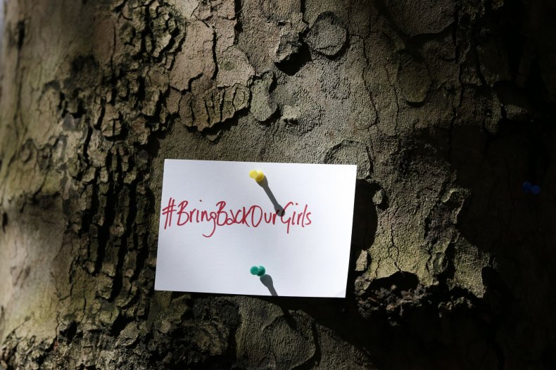 A Bring Back Our Girls sign is pinned to a tree.