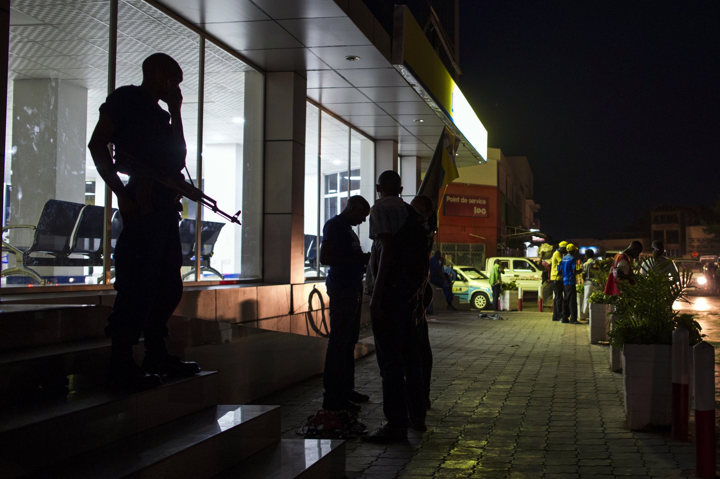 A Burundian policeman listens for news after the elections in Bujumbura.