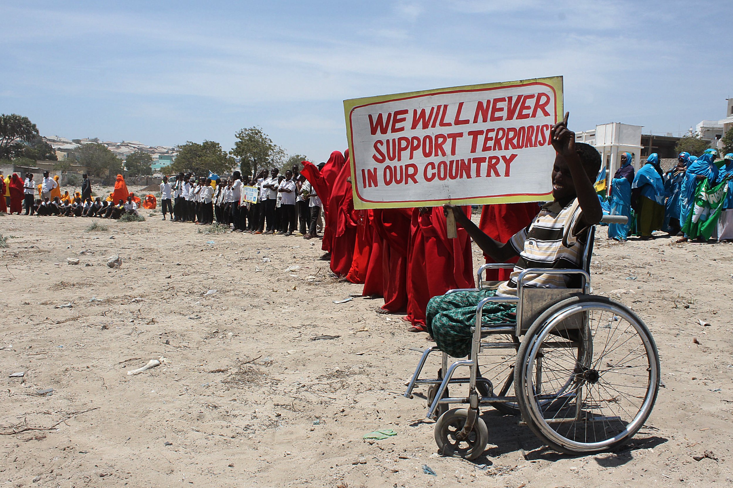 Disabled Somali boy with anti Al-Shabab poster.