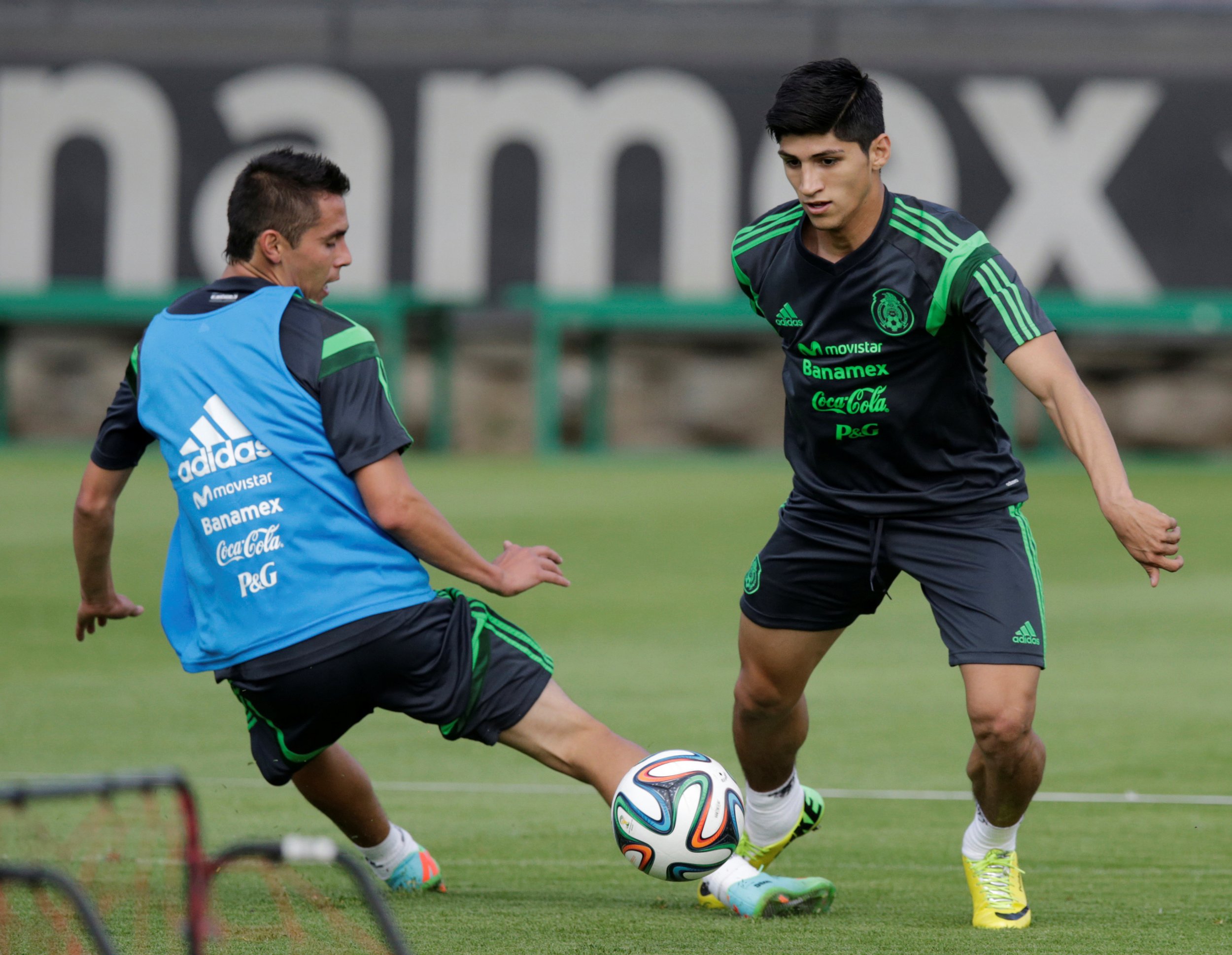 Mexico striker Alan Pulido dribbles past teammate.