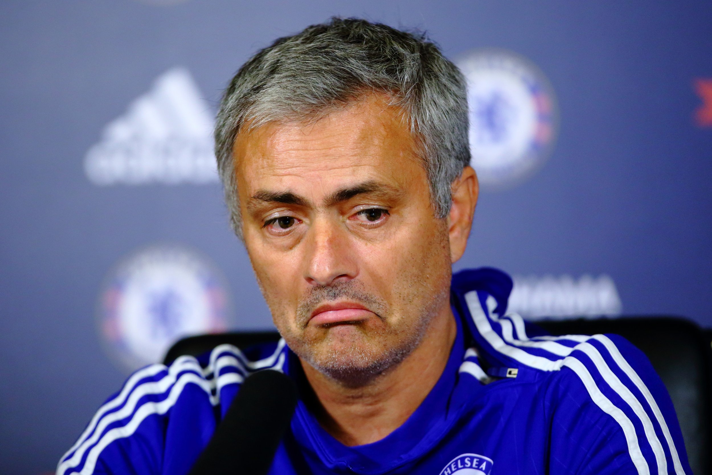  Jose Mourinho looking down with a facial expression of disapproval during a press conference.