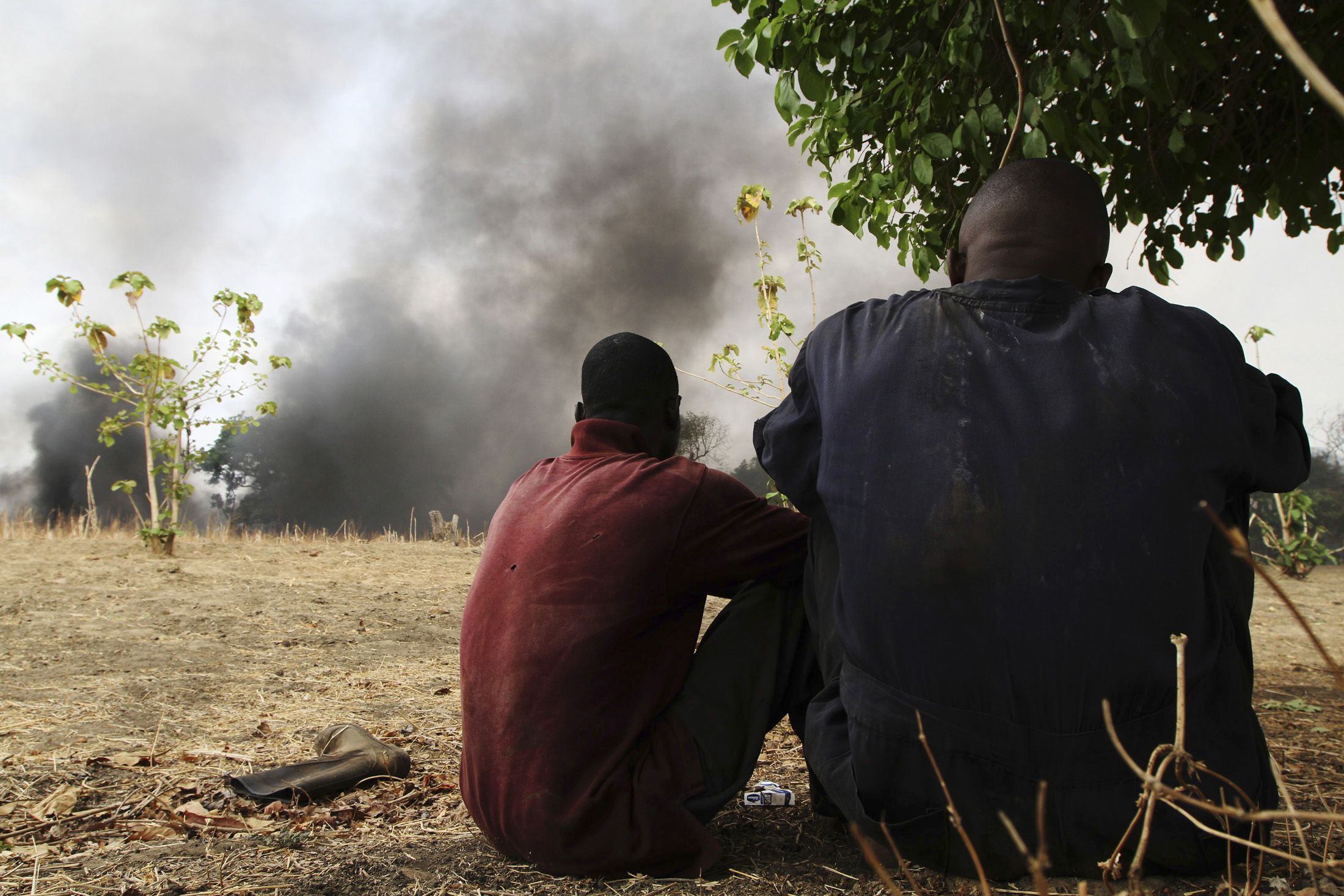 Workers in the Niger Delta watch a pipeline fire